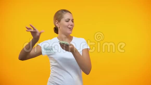 无忧无虑的女人到处乱扔钱富有的女人浪费钱消费主义视频的预览图