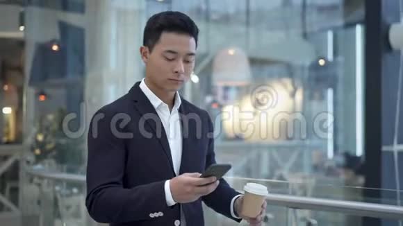 亚洲年轻商人在商务中心打电话喝咖啡视频的预览图