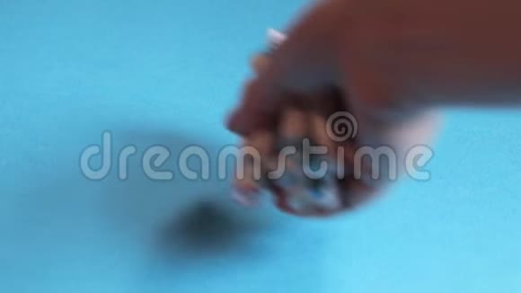 一只手把一叠牙刷头放在蓝色背景上视频的预览图