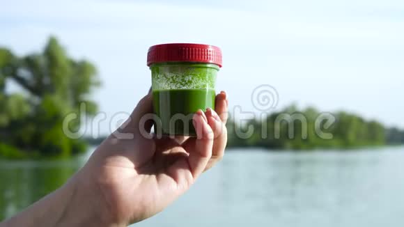 特写雌性手拿着装有绿藻的容器旋转一下视频的预览图
