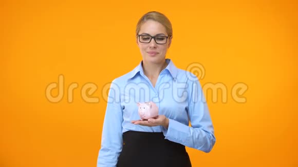 微笑的商务女士把钱存钱罐放亮背景银行存款视频的预览图