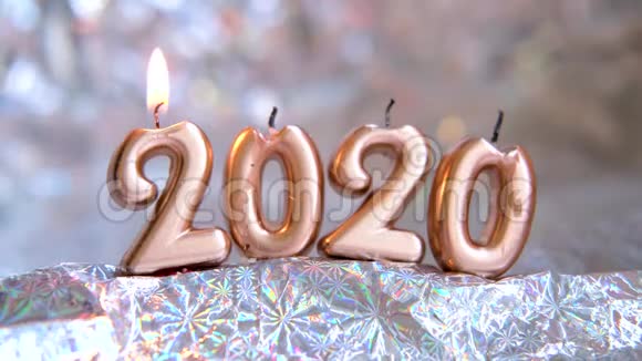 女子手中点亮一盏烛光2020金色的蜡烛在燃烧模糊的银色背景圣诞快乐新年快乐视频的预览图