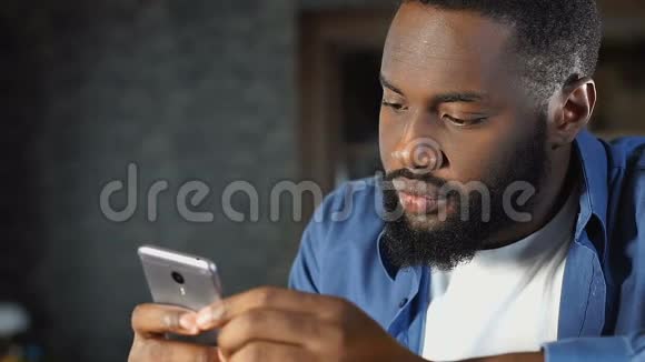英俊的非洲裔美国人在约会网站上阅读简介在线服务视频的预览图