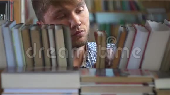 年轻人在书架上浏览视频的预览图