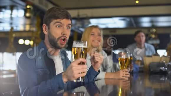 在酒吧享受体育项目的朋友为胜利而喝酒啤酒传统视频的预览图
