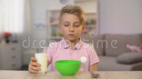 学生在准备好的母亲准备的麦片碗里倒牛奶快速早餐健康视频的预览图