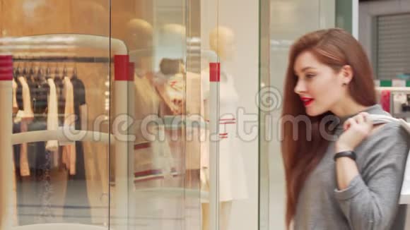 漂亮的女人喜欢在商场购物检查陈列的衣服视频的预览图