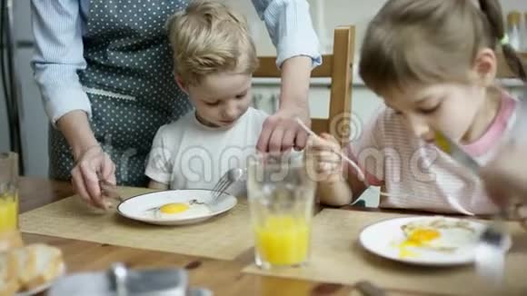 在家庭晚餐期间妈妈给儿子切了些鸡蛋视频的预览图