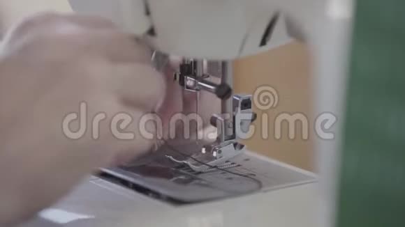 裁缝的特写手在开始工作前将线插入缝纫机的针中概念视频的预览图