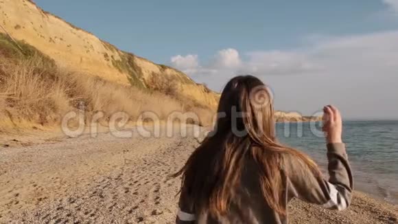 年轻的黑发女孩与日本白狗慢动作坐在海边视频的预览图