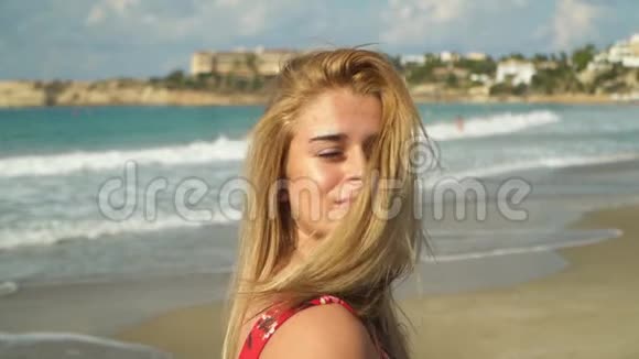 年轻的金发女人摇了摇头使她的金发在海洋背景上缓慢地飘动孤独女孩视频的预览图