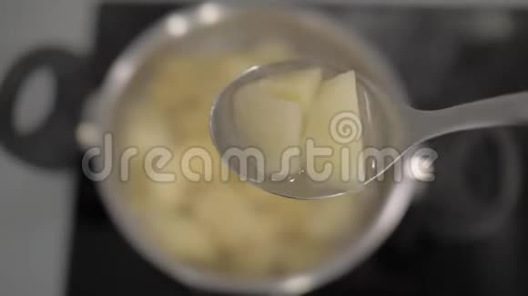 土豆片放在一个大汤匙里放在土豆锅的背景上4k4k视频视频的预览图