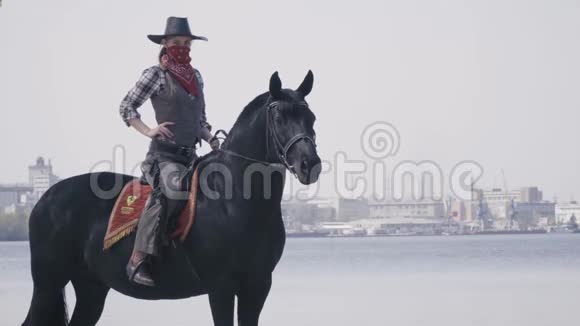 戴着面具的牛仔正坐在沙滩上的马背上4k视频的预览图