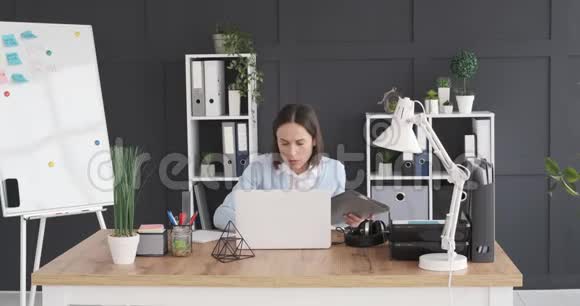 女商人把档案放在架子上在办公桌上用笔记本电脑视频的预览图