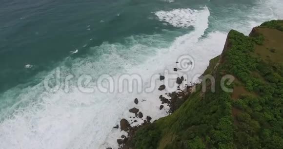 海浪拍打着岩石和泡沫五颜六色的镜头巴厘岛4k视频的预览图