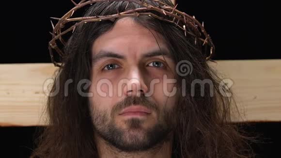 在荆棘冠冕上哭泣的耶稣基督在十字架上钉十字架视频的预览图