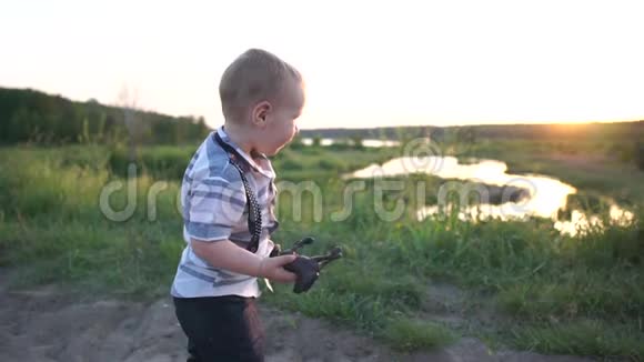 一个小男孩手里拿着一个小马玩具在日落时快乐地和它一起在路上奔跑视频的预览图