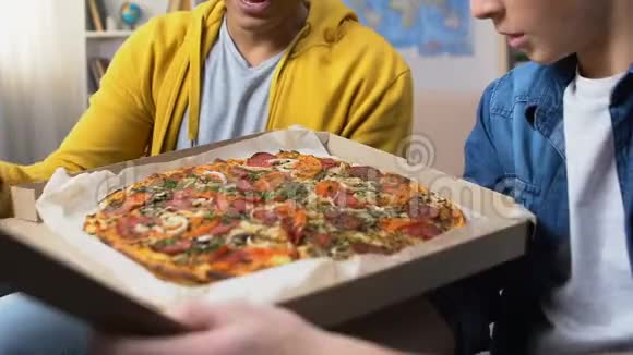 两个男学生打开披萨盒看着美味的热餐快餐视频的预览图