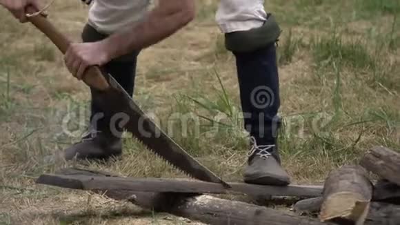 人用手锯在外面锯木板男人手里拿着锯子视频的预览图