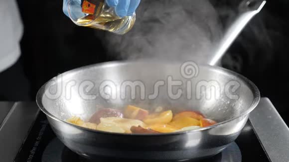 慢动作食物视频弗拉姆风格的菜肴烹饪快关门厨师在煎锅上倒入干邑和水果厨师视频的预览图