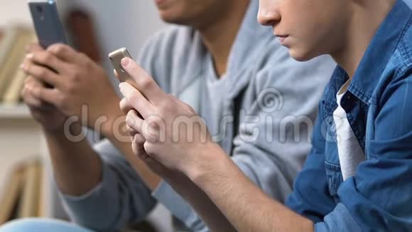 两名青少年在智能手机上玩快速电子游戏手机游戏应用程序视频的预览图