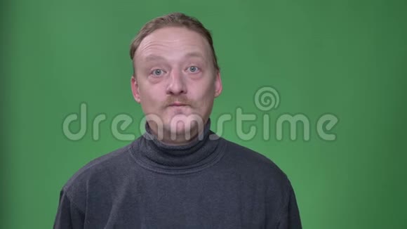 留着胡子的中年男子的肖像带着惊喜地笑着在绿色的背景上给相机五张视频的预览图