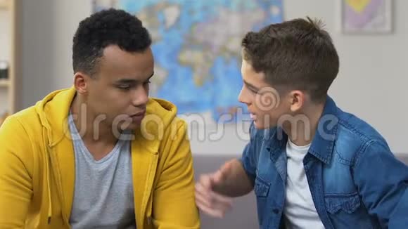 两个十几岁的男孩在沙发上争吵高中的关系问题视频的预览图
