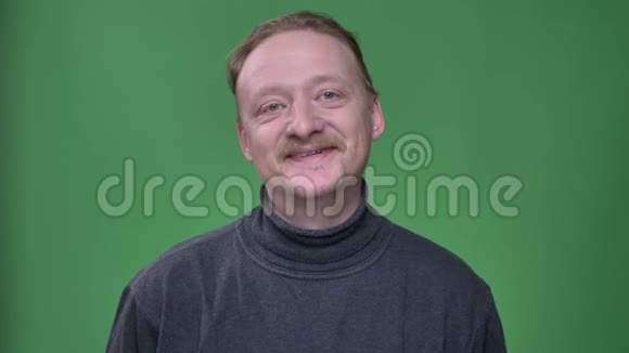 留着胡子和胡子的中年男子在绿色的背景上听着高兴地和礼貌地点头视频的预览图