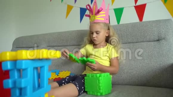 戴着皇冠的小公主从沙发上的五颜六色的部分构造了一些东西视频的预览图