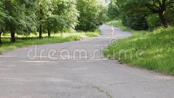 在一个阳光明媚的夏天小女孩在公园里沿着跑道跑步视频的预览图
