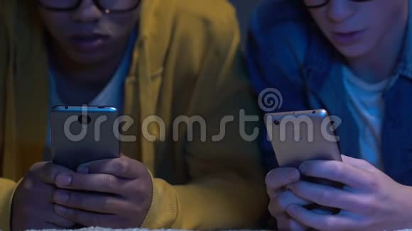 两个男性朋友深夜在智能手机上玩手机游戏过夜视频的预览图