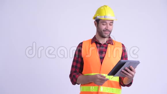 快乐留胡子的波斯人建筑工人使用数字平板电脑并竖起大拇指视频的预览图