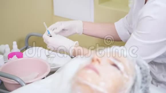 美容师将面霜涂在客户脸上做美容时的面部清洁视频的预览图