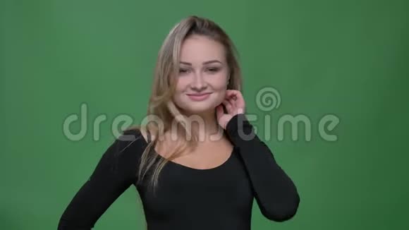 年轻女商人穿着黑色衬衫用相机调情在绿色背景下固定头发的肖像视频的预览图