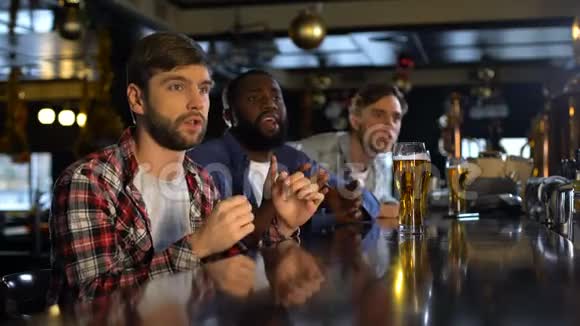 在酒吧里看体育比赛的男人为国家队的失利而苦恼视频的预览图