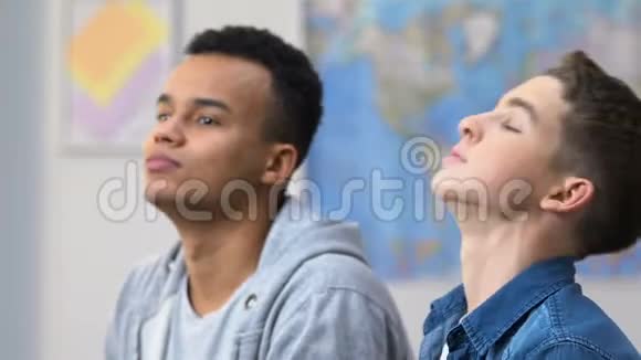 两个高中朋友看电视连续剧用嘴吃爆米花休息视频的预览图