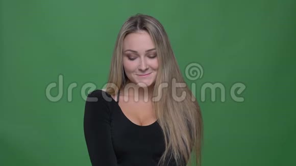 年轻女商人穿着黑色衬衫害羞地思考微笑着面对绿色背景的肖像视频的预览图