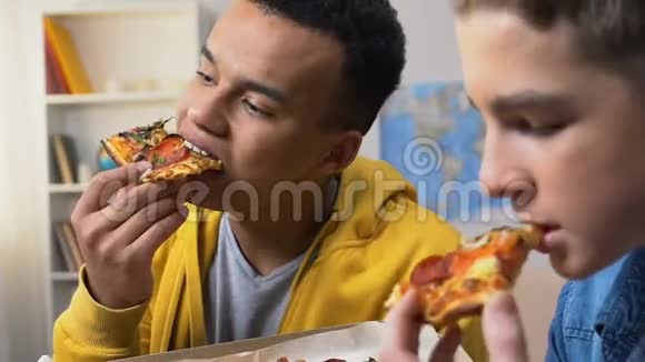 两位大学朋友享受新鲜披萨片免费提供高卡路里餐视频的预览图