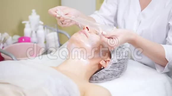 美容师在美容诊所做美容手术客户的脸颊做面部清洁视频的预览图