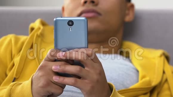 穿着黑衣服的男孩在智能手机上打字十几岁的女孩约会视频的预览图