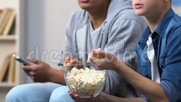 两个男朋友在看电视剧集前吃爆米花视频的预览图