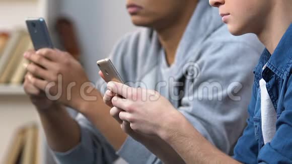 两名男性青少年使用智能手机在线聊天社交媒体关系视频的预览图
