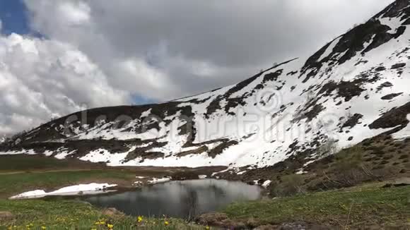 山坡上覆盖着雪绿色的积云迅速飞越蓝天视频的预览图