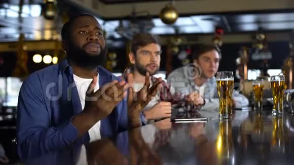 多种族的男性朋友在酒吧里观看体育比赛享受胜利放松视频的预览图