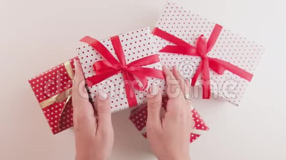 女人的手拿着用丝带摇动手工制作的圣诞礼盒视频的预览图