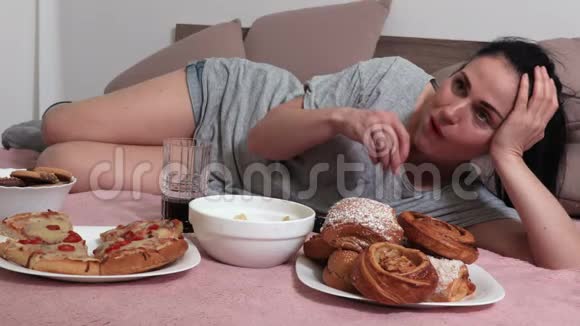 女人躺在床上吃薯片喝汽水用遥控器视频的预览图