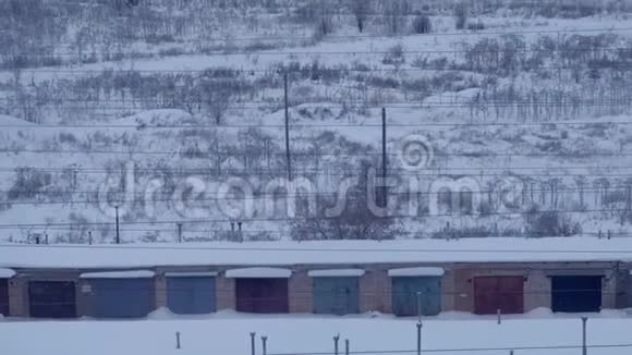 冬季雪中靠近电力线的汽车车库数量视频的预览图