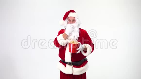 圣诞节白色背景上的圣诞老人带着一个带爆米花的红色桶有爆米花看电影情绪视频的预览图