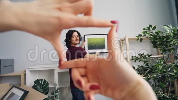 年轻男子选择拍照的地方而女朋友帮助他打手势视频的预览图