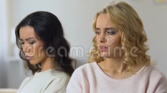两个被冒犯的女人分别坐在沙发上看着对方吵架视频的预览图